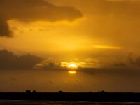 Untergehende Sonne mit schmalem Wolkenband